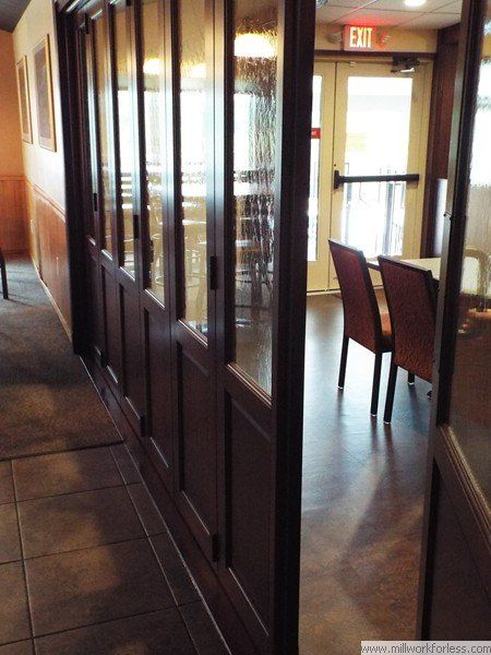A hallway with a red exit sign above the door