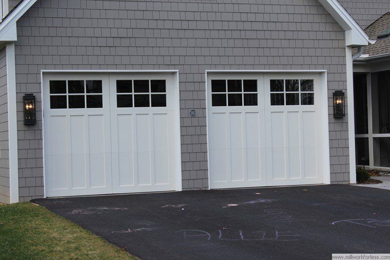There are two garage doors on the side of a house.