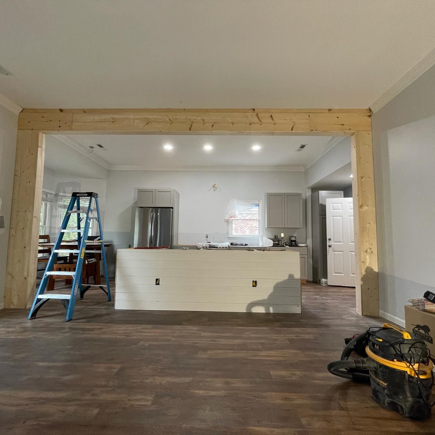 A kitchen under construction with a ladder and a bag on the floor