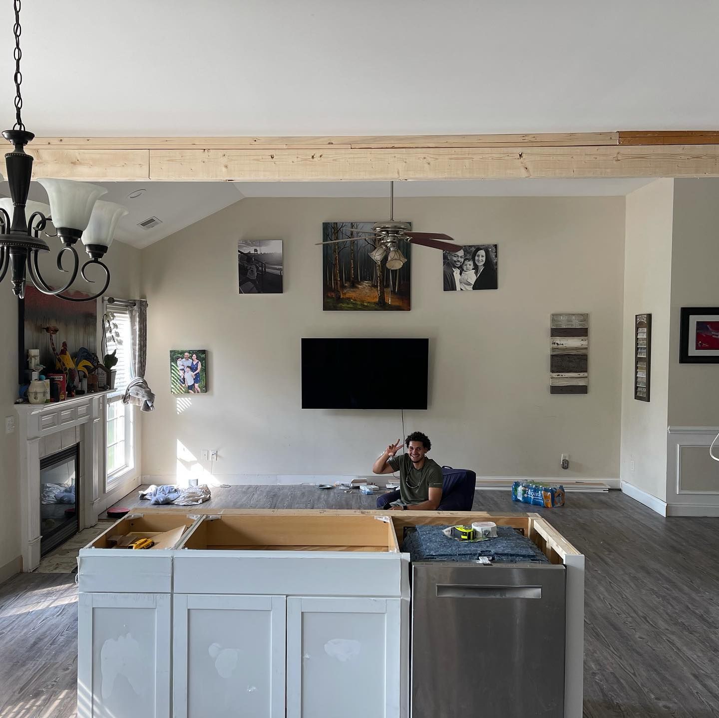A man is sitting on a couch in a living room in front of a flat screen tv