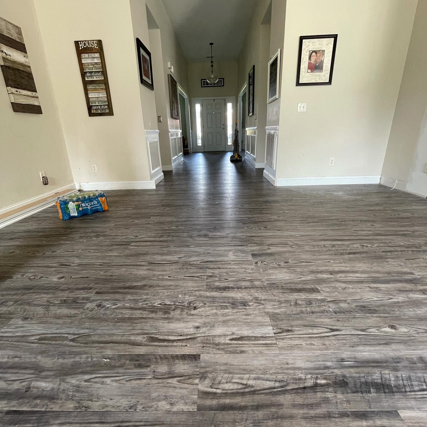 A long hallway with a wooden floor in a house.