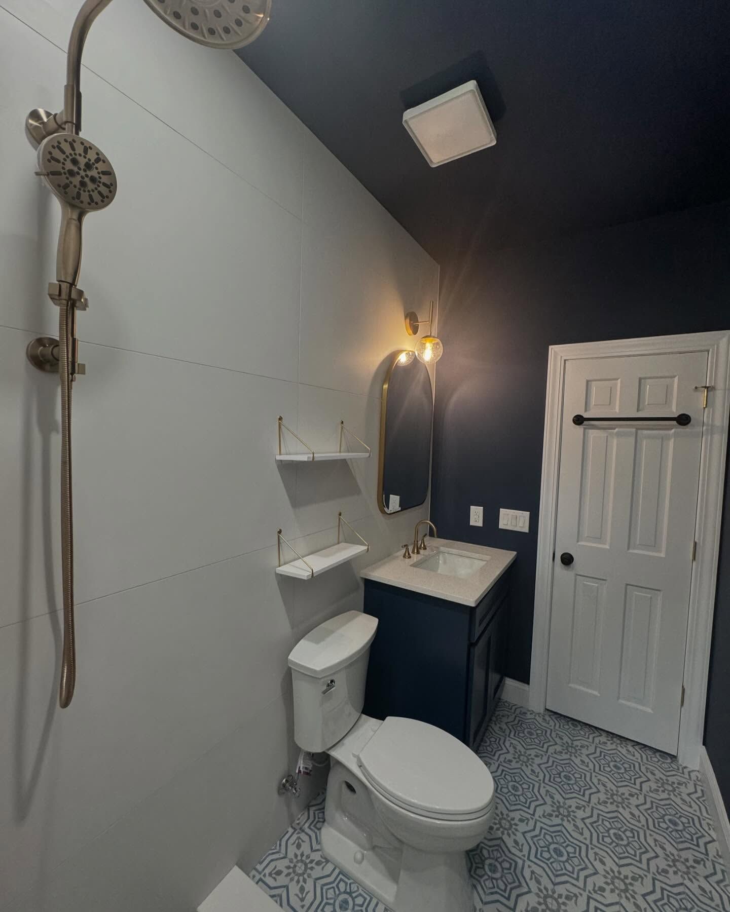 A bathroom with a toilet , sink , shower and mirror