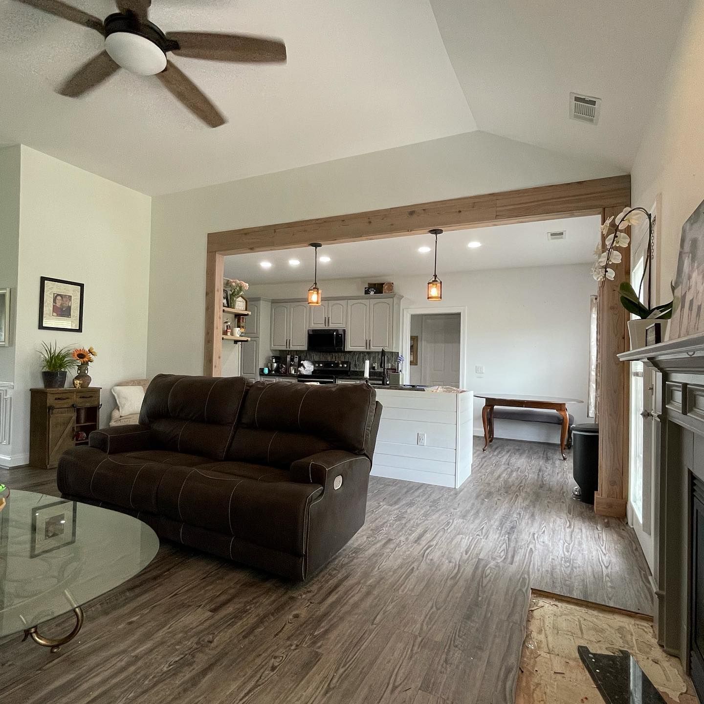 A living room with a brown couch and a ceiling fan