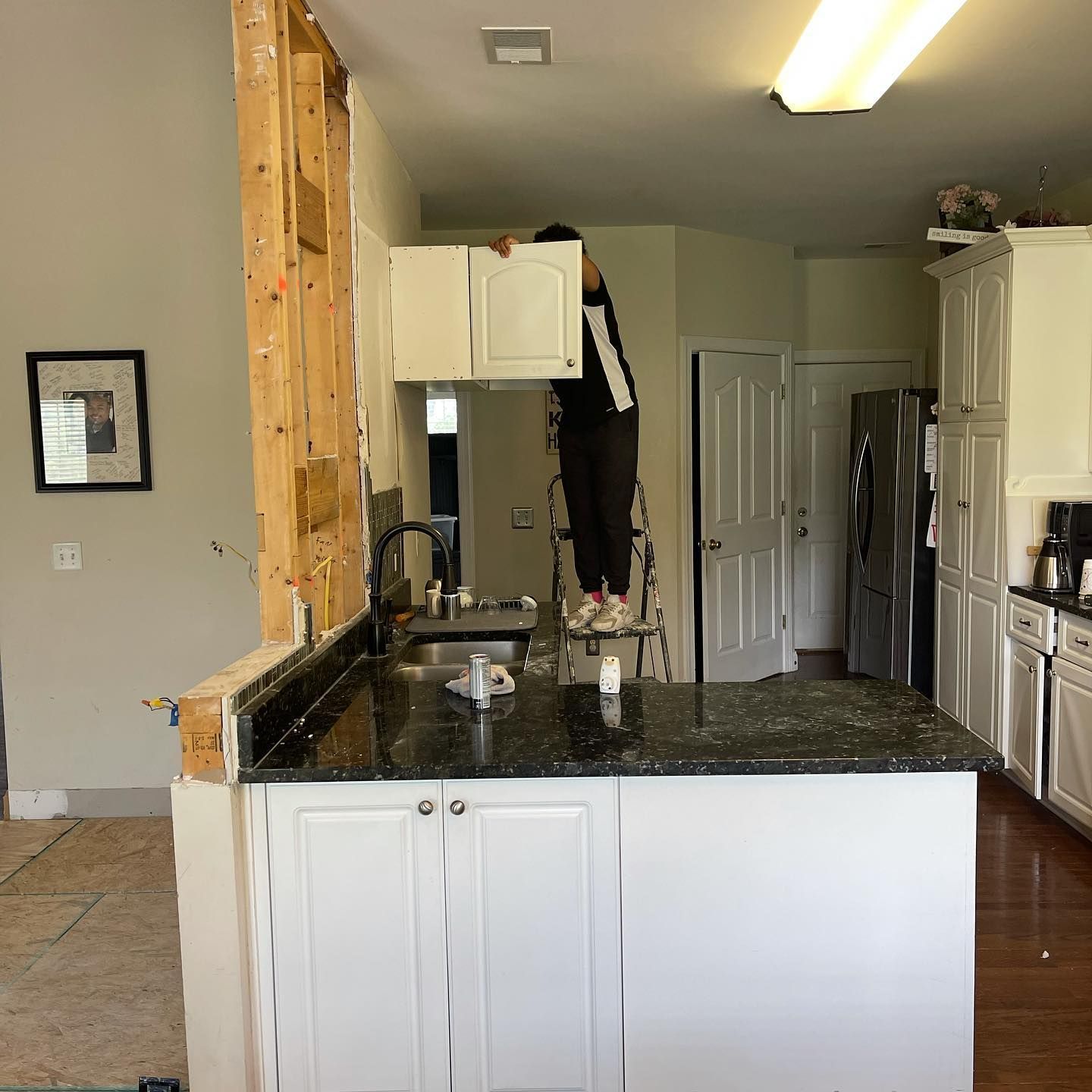 A person standing on a ladder in a kitchen
