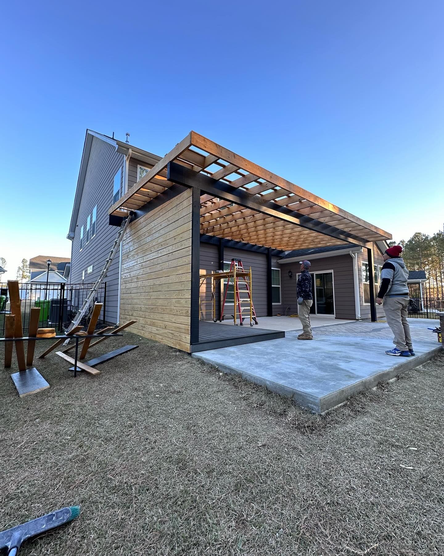 A group of people are standing in front of a house under construction.
