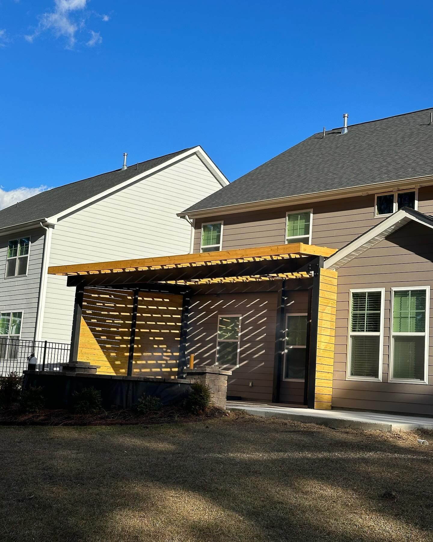 A house with a yellow pergola in front of it