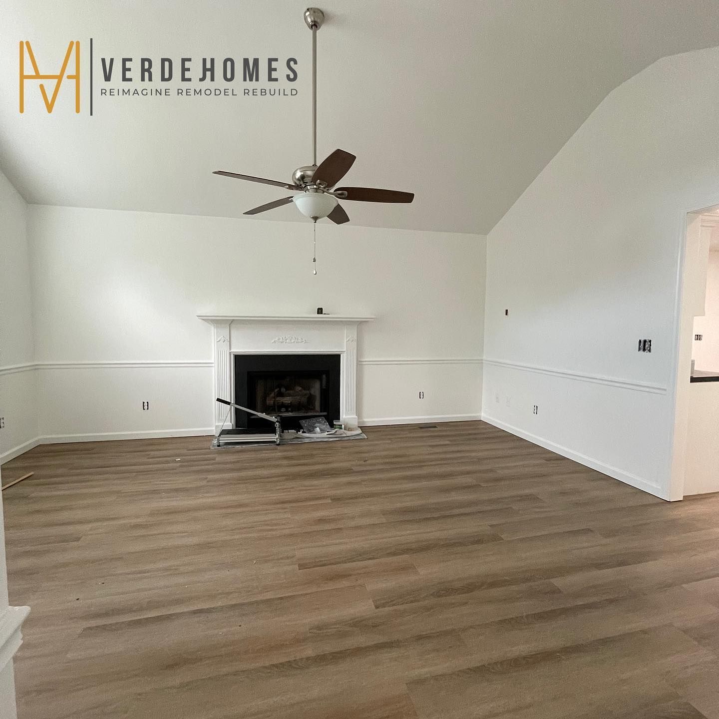 A living room with a fireplace and a ceiling fan
