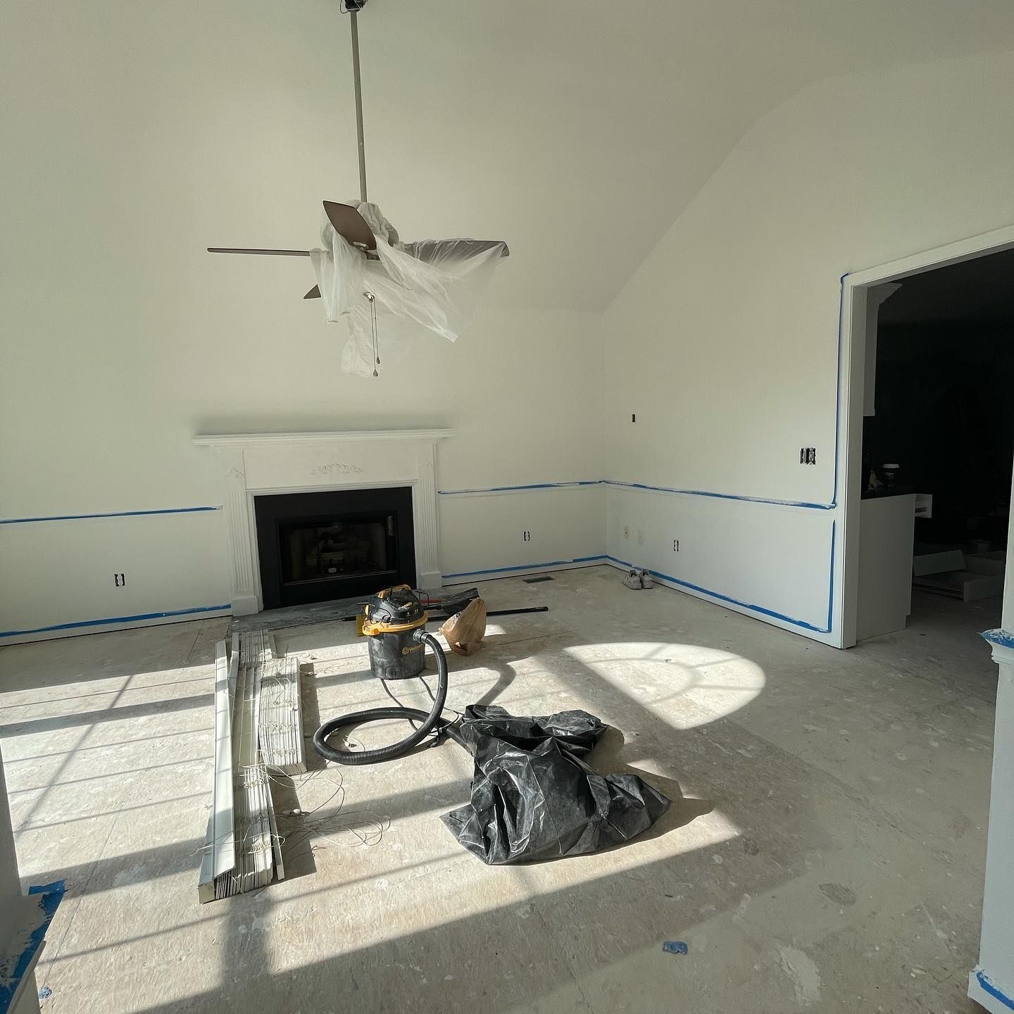 A living room with a fireplace and a ceiling fan.