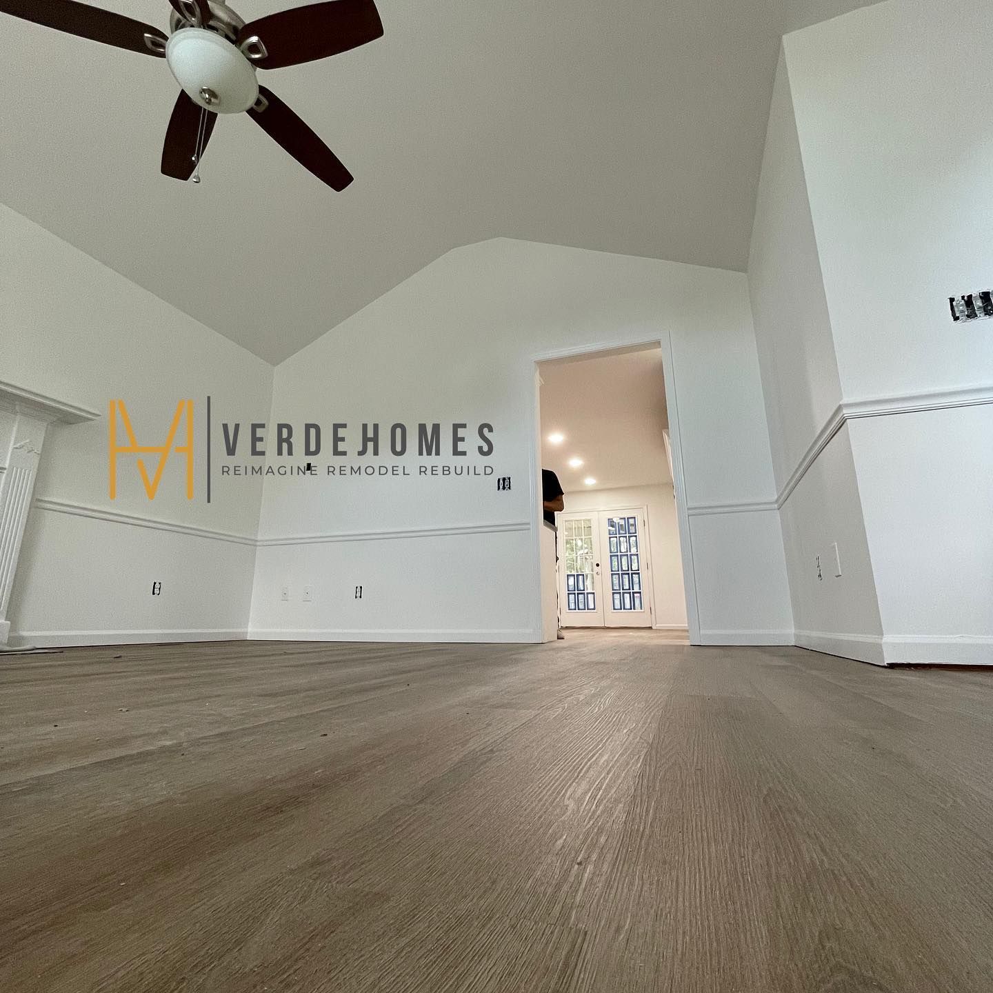 A large room with a ceiling fan and the word verdehomes on the wall