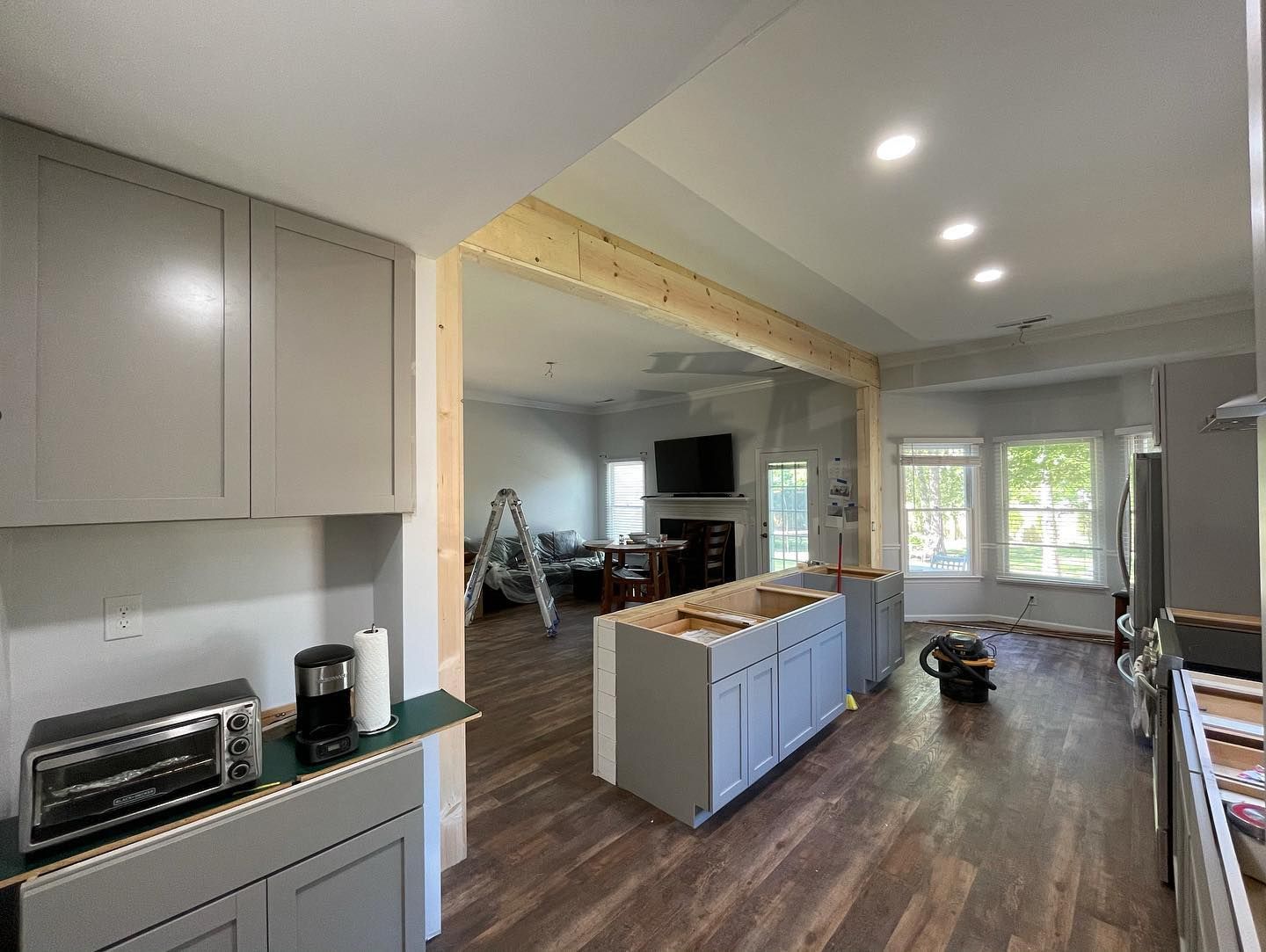 A kitchen with gray cabinets and wooden floors is being remodeled.