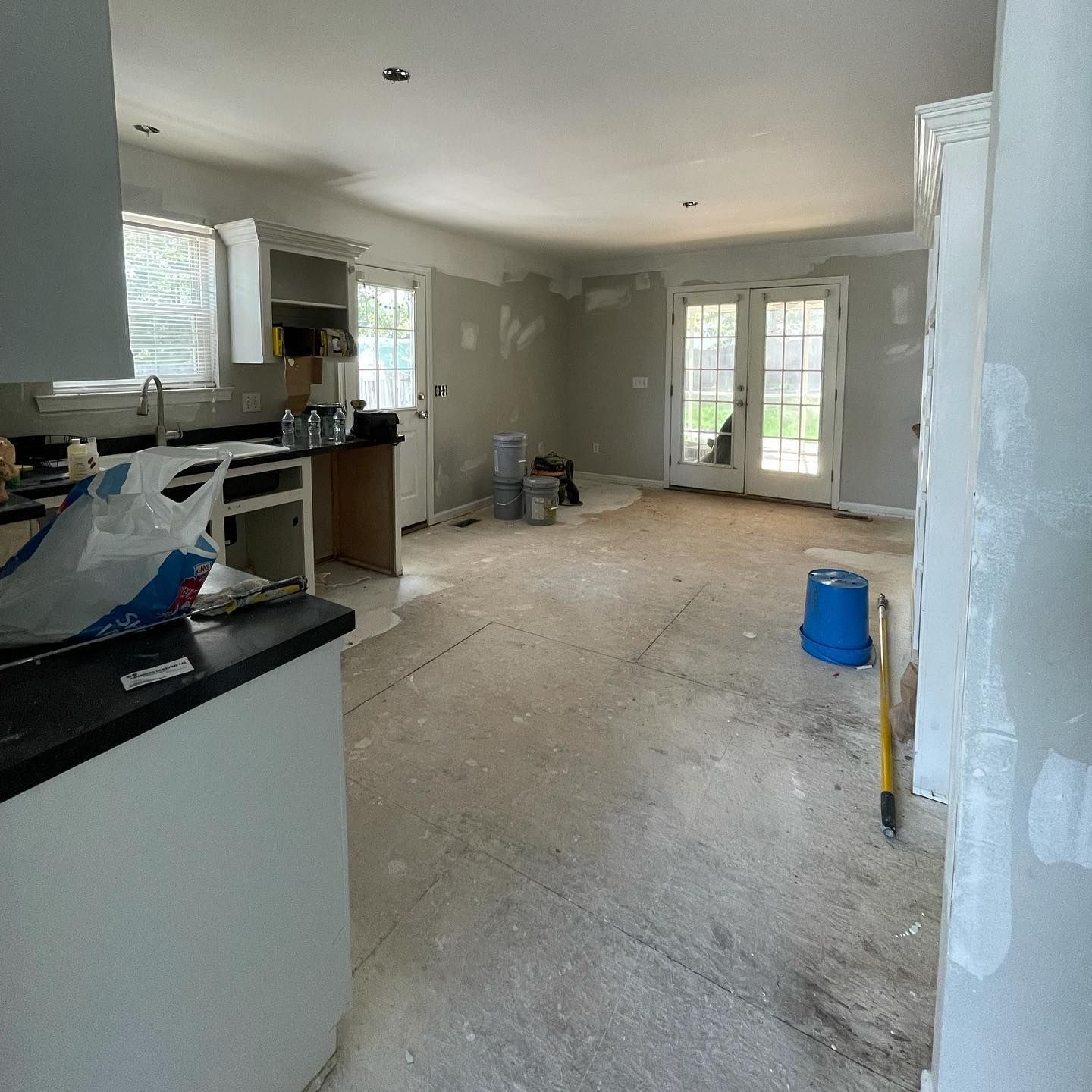 A kitchen is being remodeled with a bucket of paint on the floor