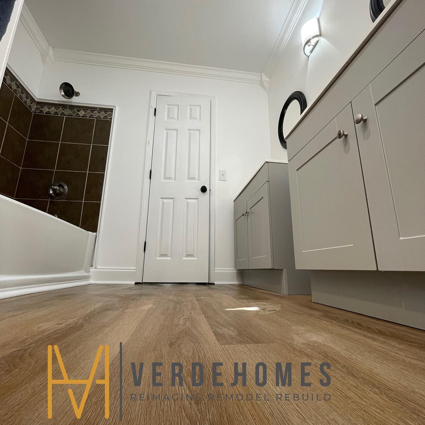 A bathroom with a wooden floor and a sign that says verdehomes