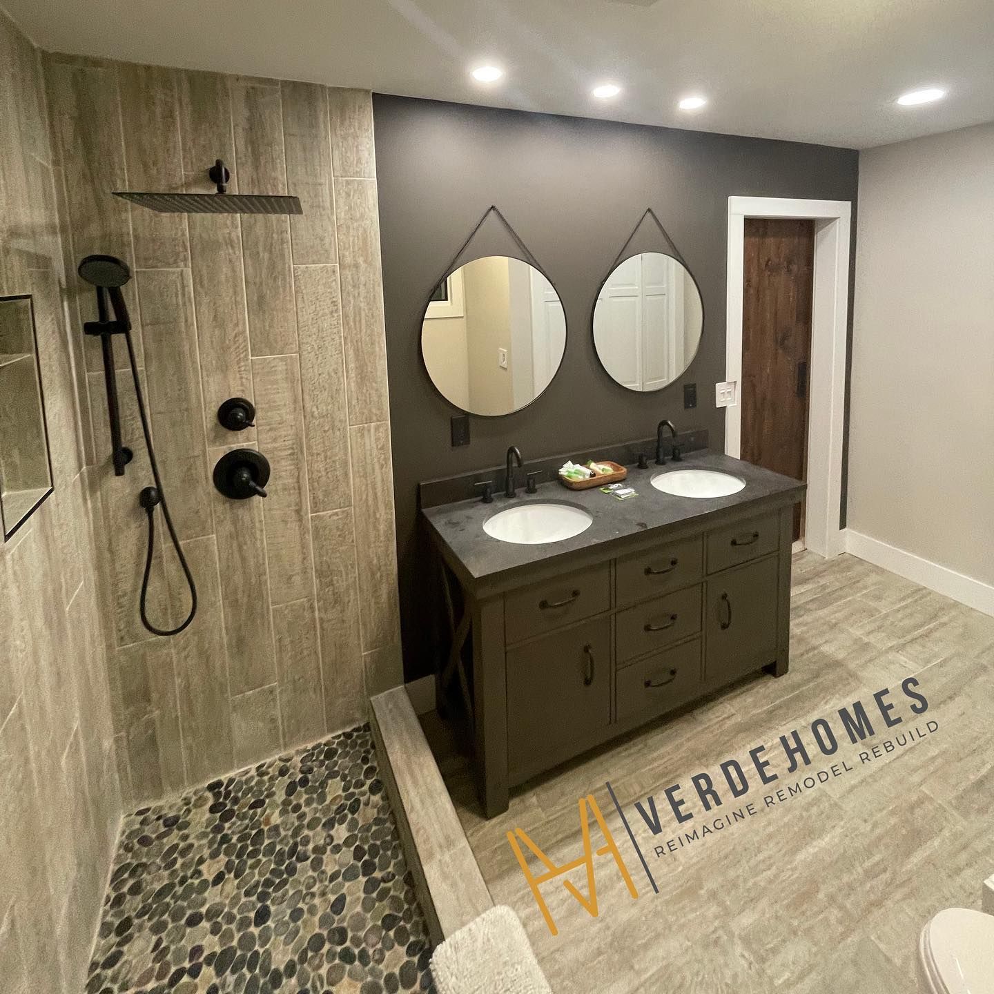 A bathroom with two sinks and a walk in shower.