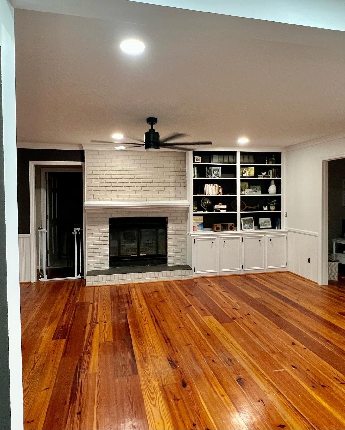 A living room with hardwood floors and a fireplace.