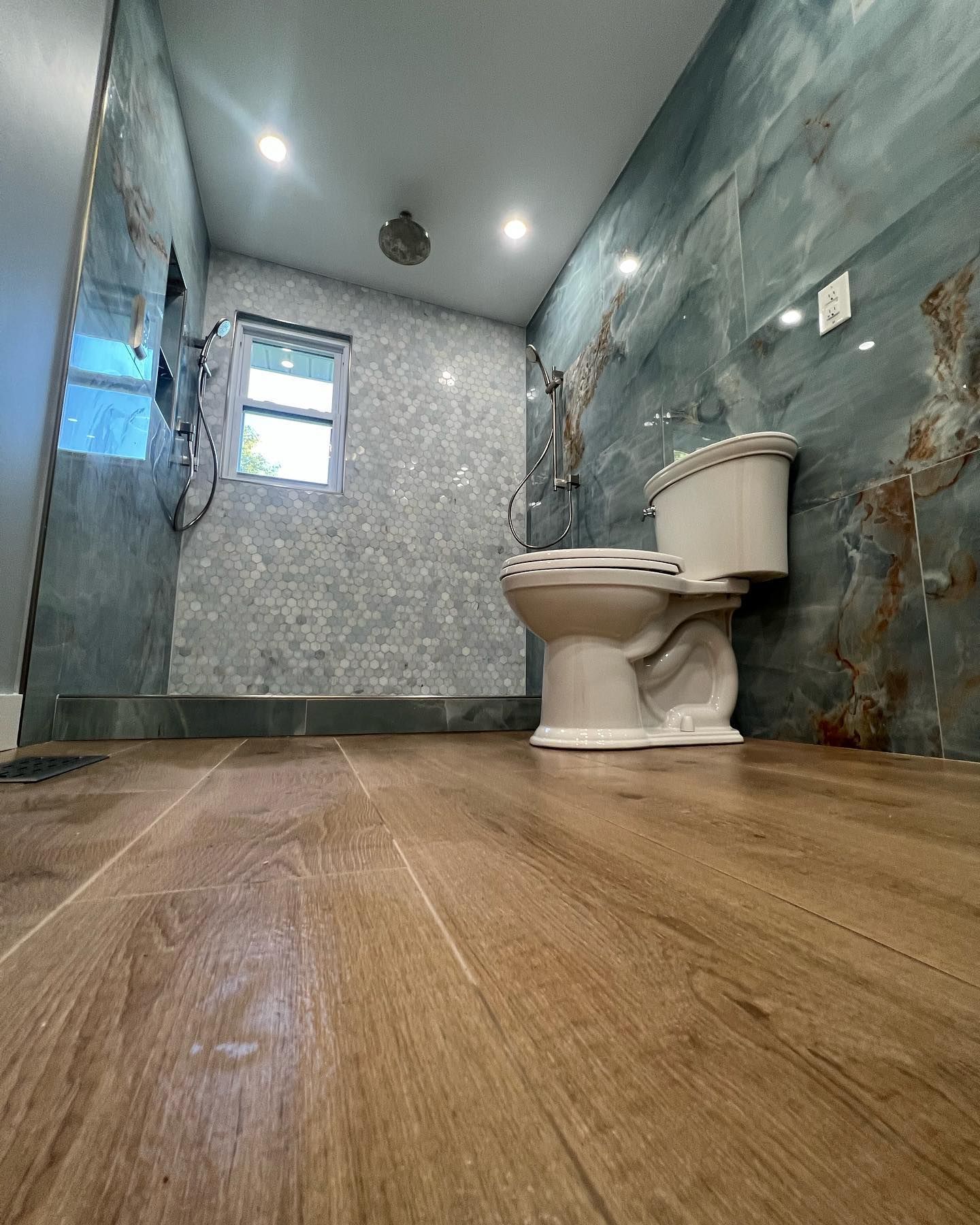 A bathroom with a toilet and a window.