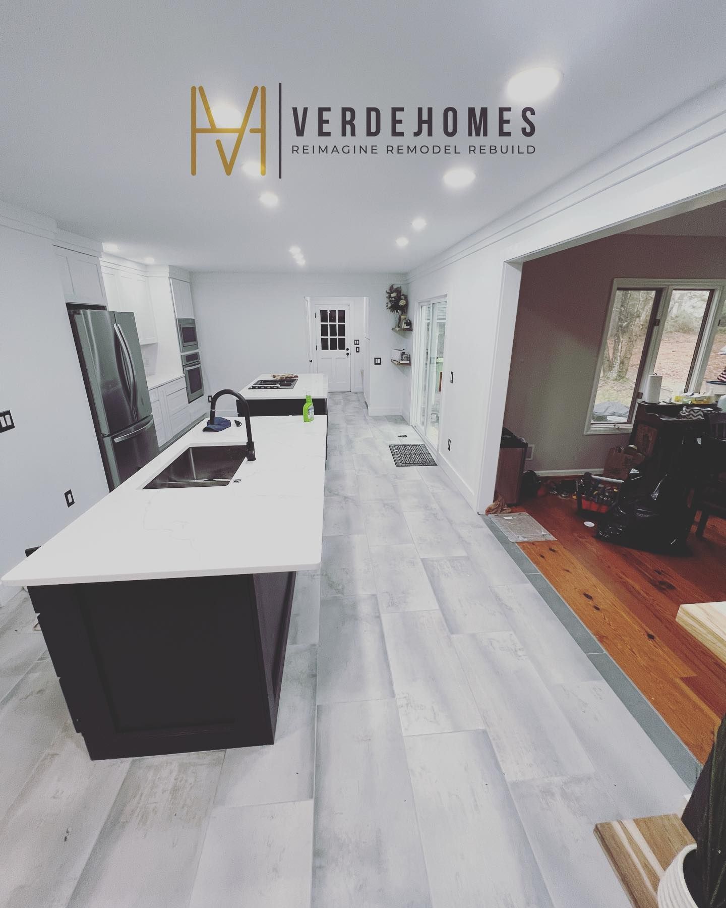 A kitchen with a large island and a logo for verdehomes