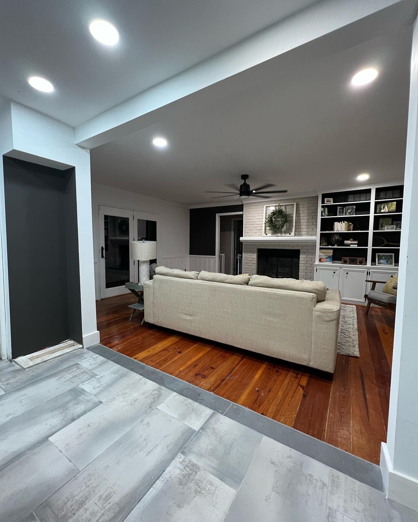 A living room with a couch , fireplace and ceiling fan.