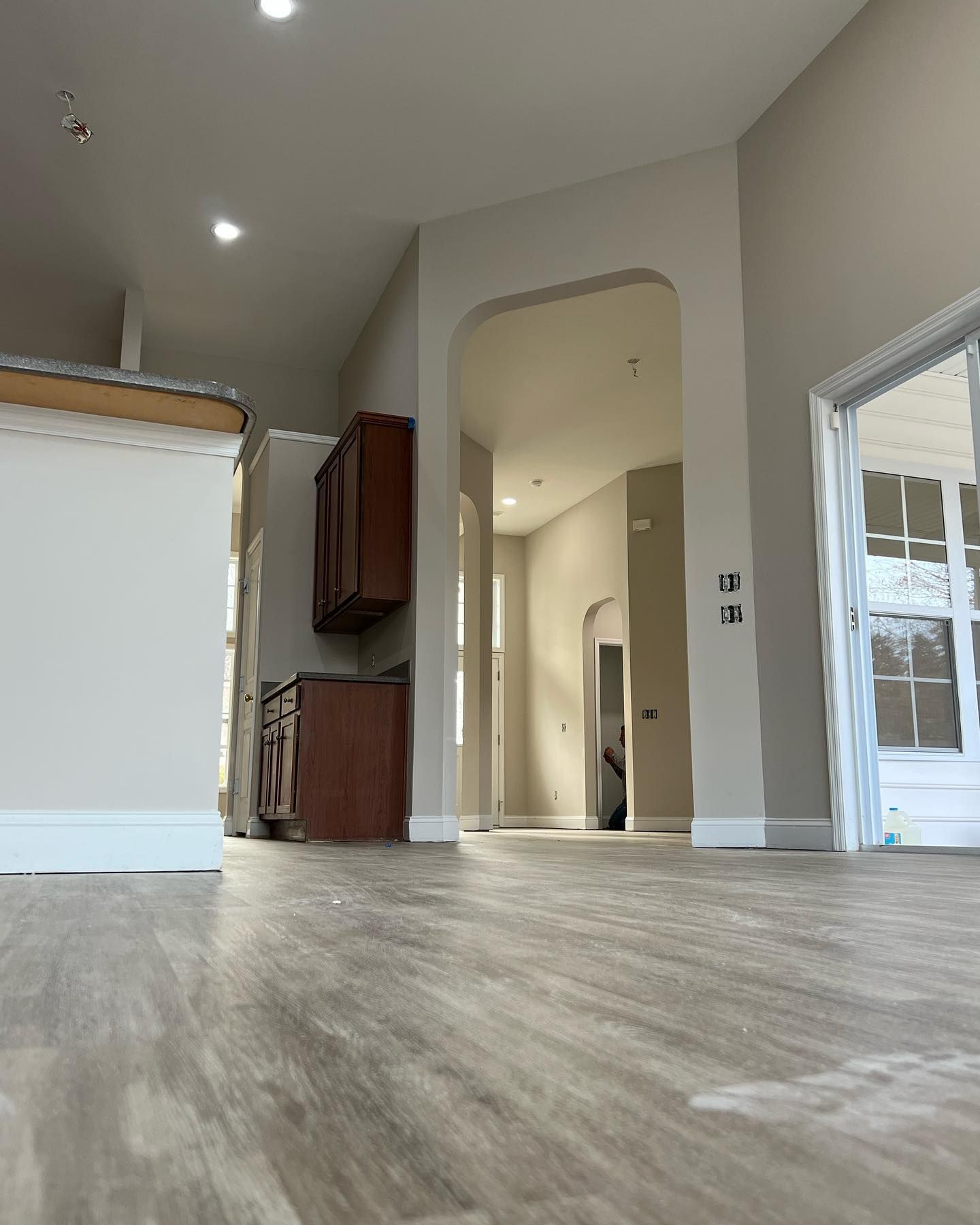 A kitchen with a wooden floor and a sliding glass door.