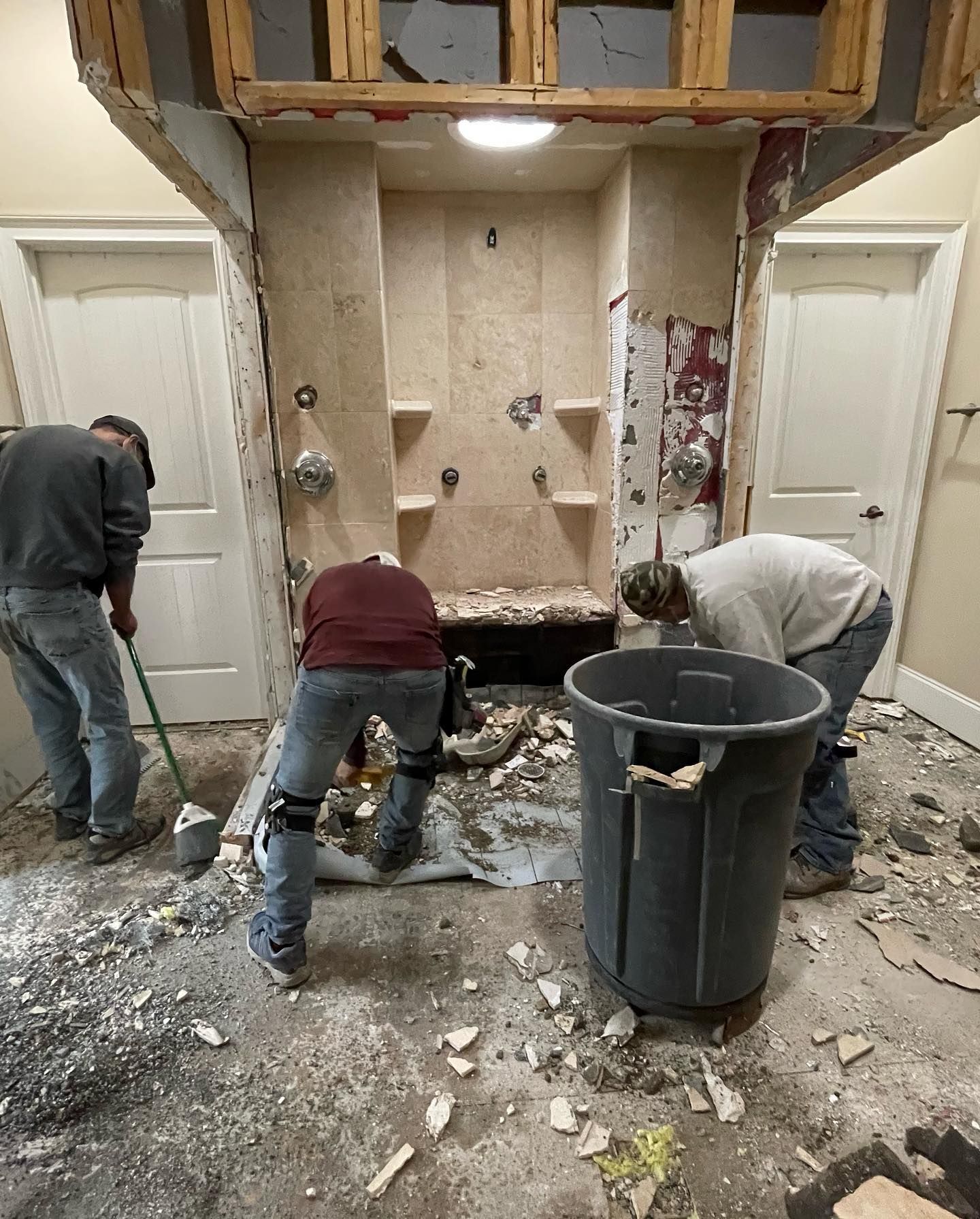 A group of men are working on a bathroom remodel.