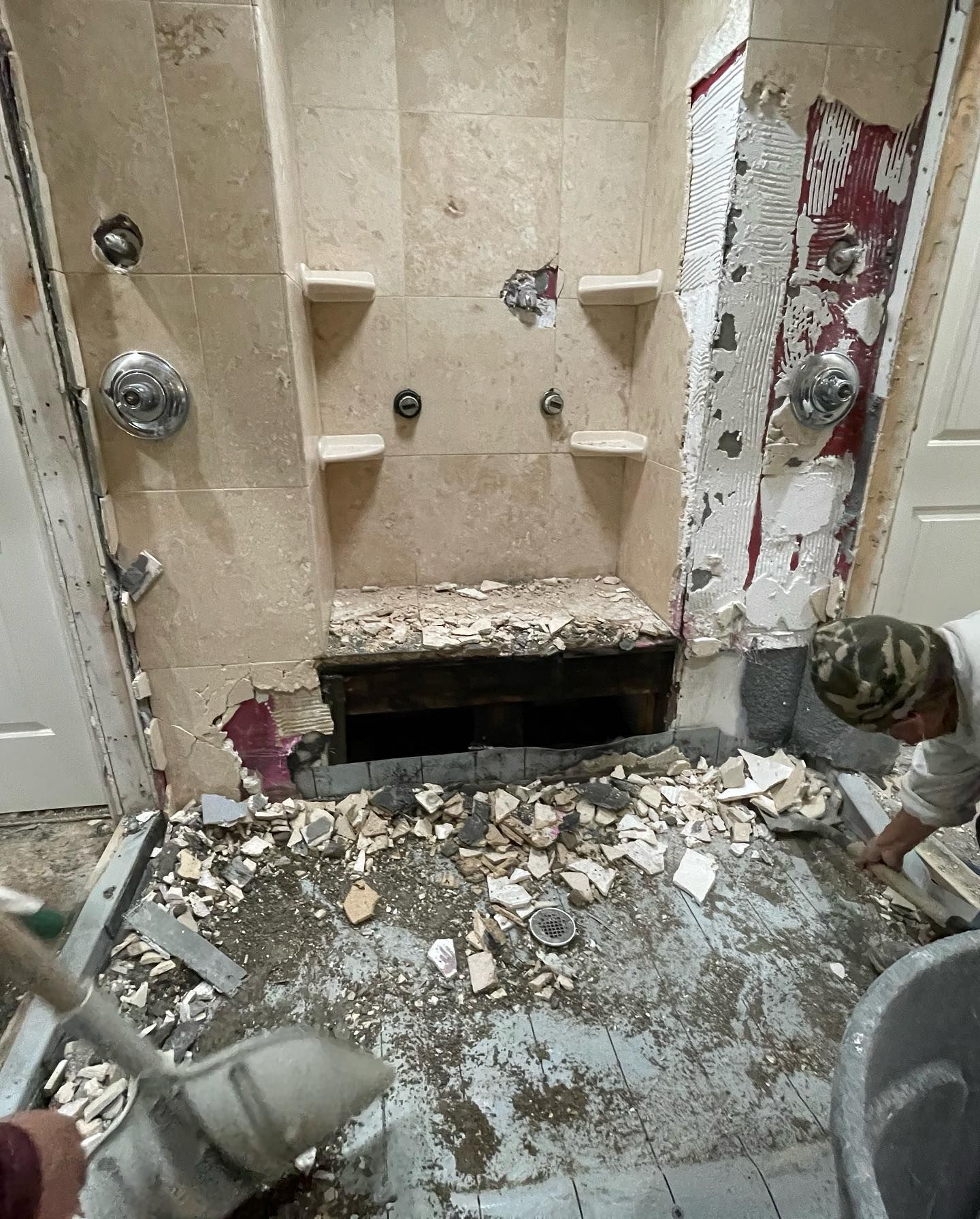 A man is cleaning the floor of a bathroom.