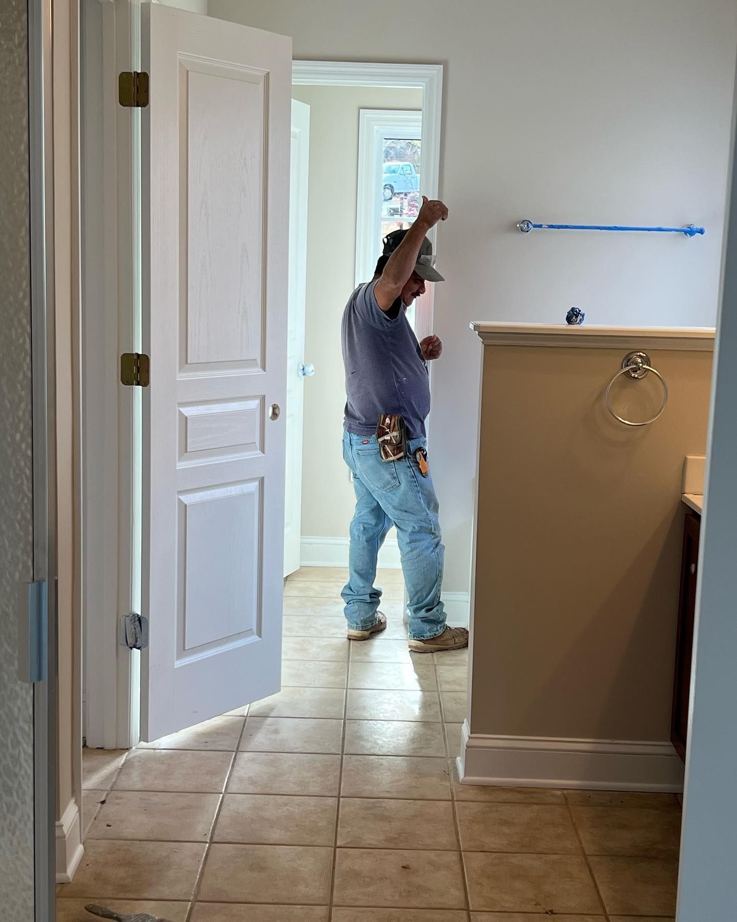 A man is standing in a room with a white door