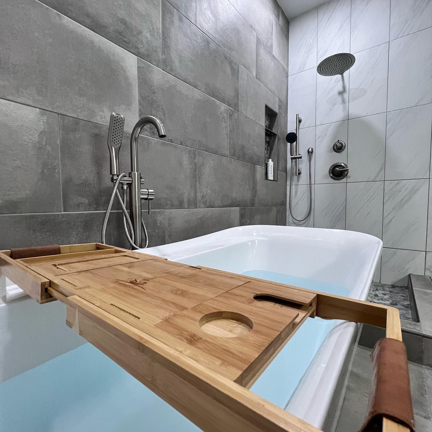 A bathtub with a wooden tray on top of it