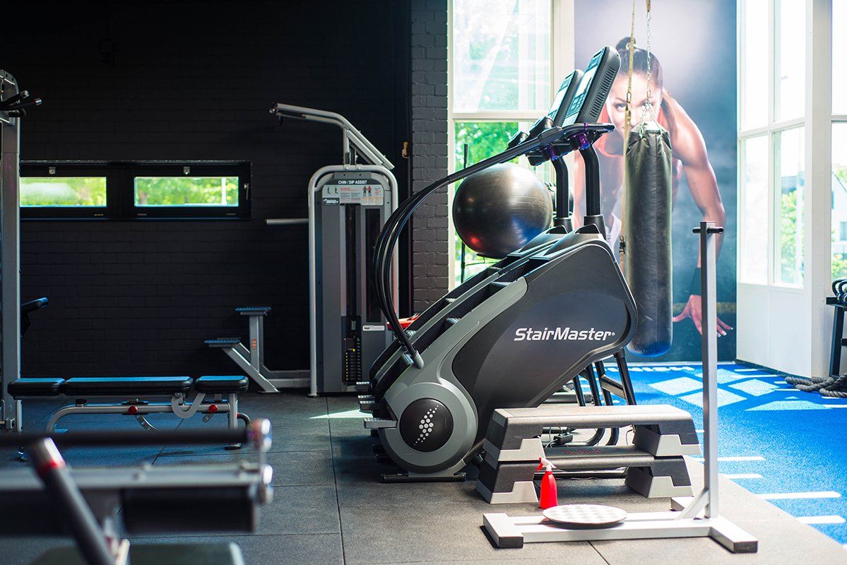 een sportschool met veel apparatuur en een foto van een man aan de muur.