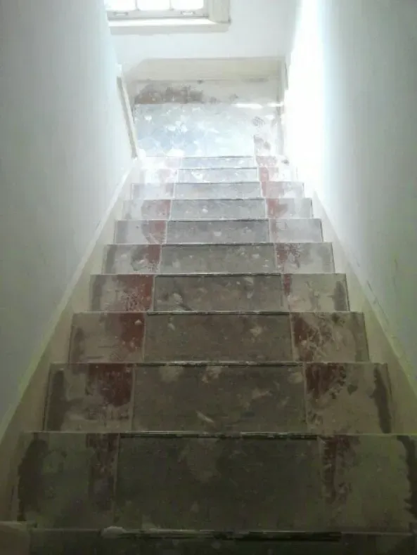 A set of stairs leading up to a window in a building.
