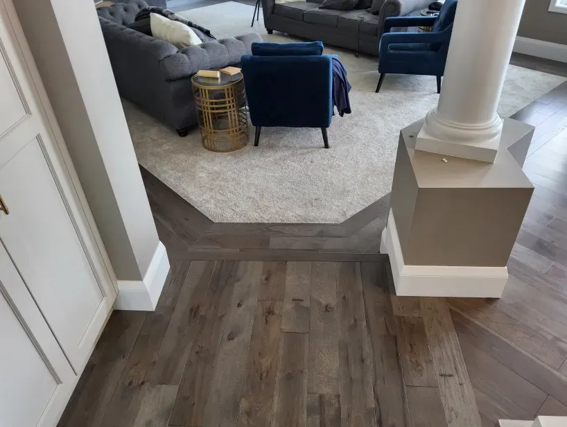 A living room with hardwood floors and a couch and chairs