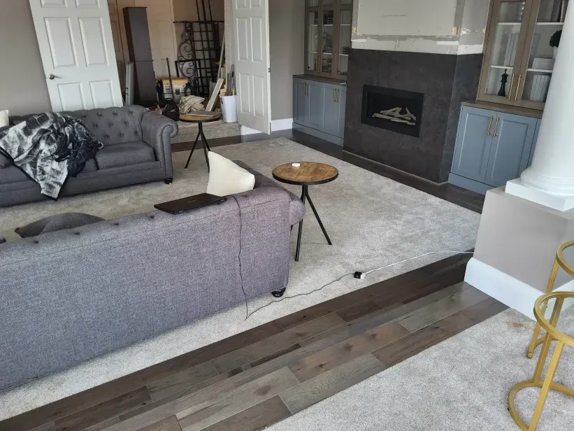 A living room with a couch , chair , table and fireplace.