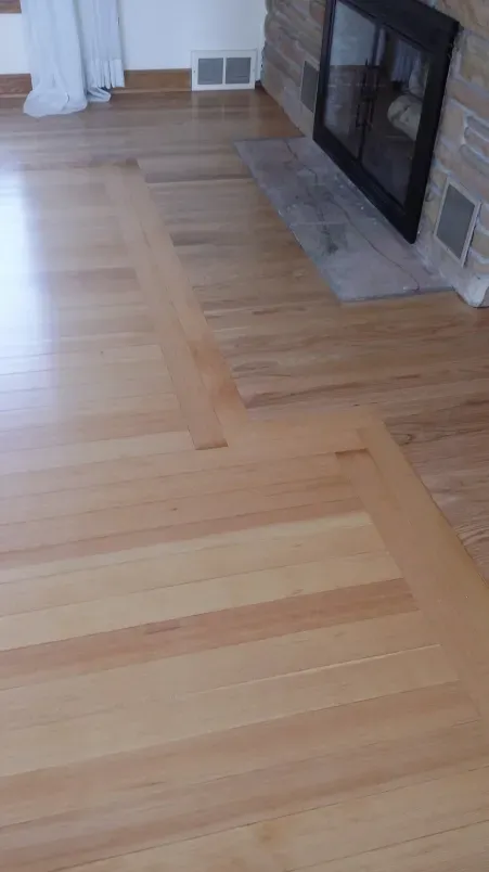 A living room with hardwood floors and a fireplace.