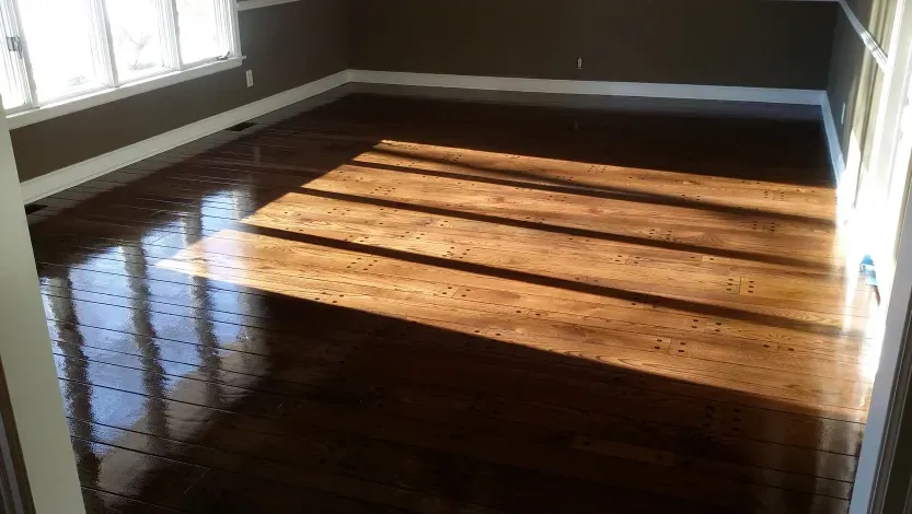 A living room with a wooden floor and a lot of windows.