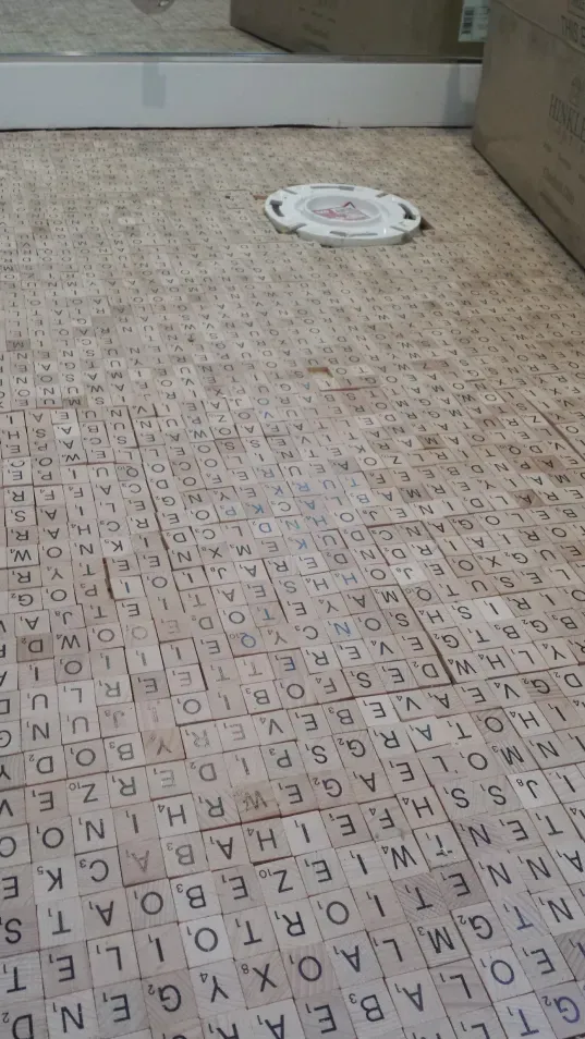 A bathroom floor with a lot of letters on it