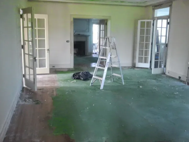 An empty room with a ladder in the middle of it