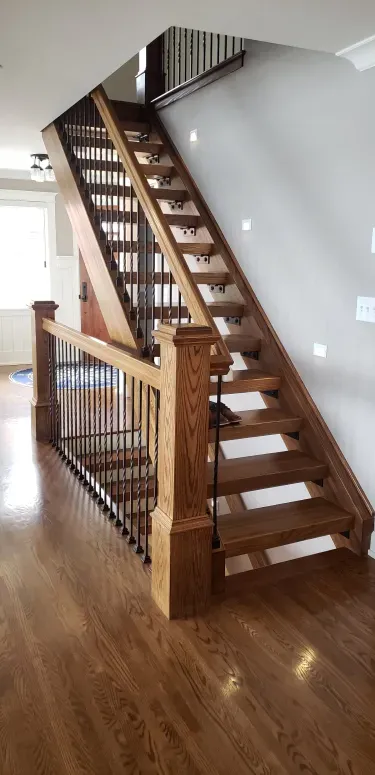 A wooden staircase with a metal railing in a house.
