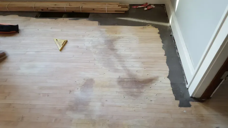 A wooden floor with a triangle and a level on it