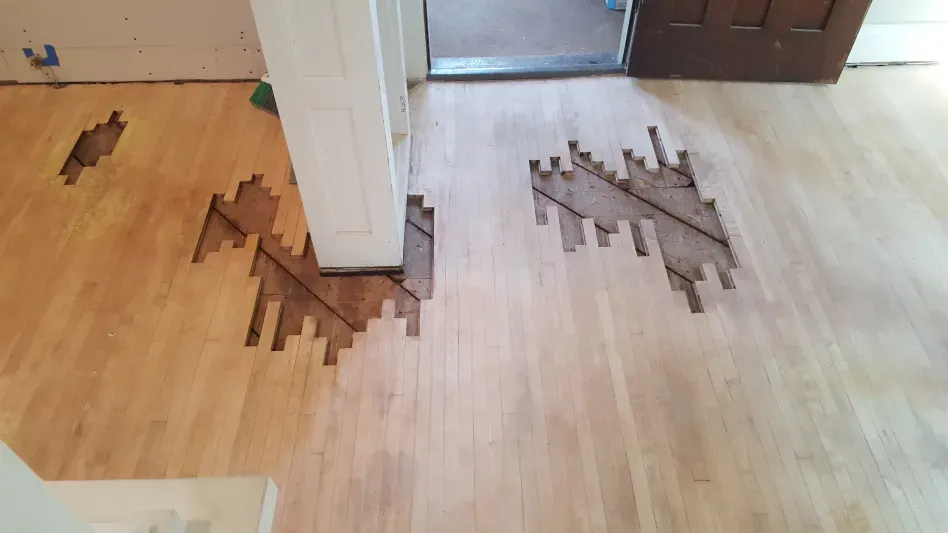A wooden floor with a few pieces of wood missing from it.