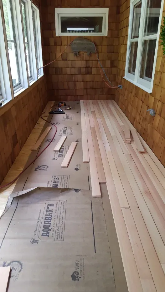 A room with wooden floors and a lot of windows.