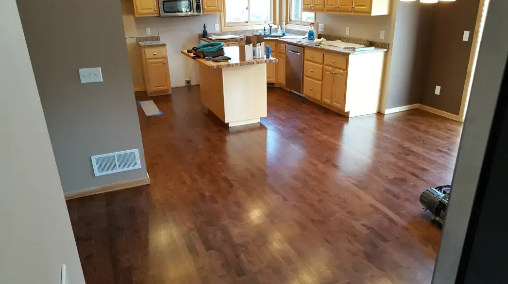 A kitchen with hardwood floors and stainless steel appliances.