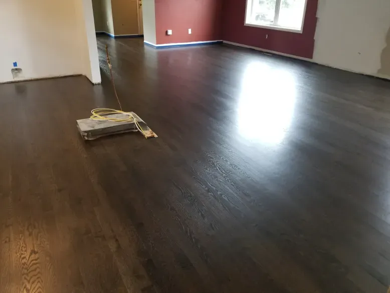 A living room with a wooden floor and a window.