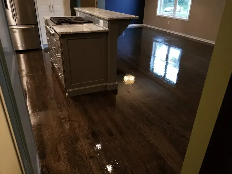 A kitchen with a wooden floor and a stove top oven.