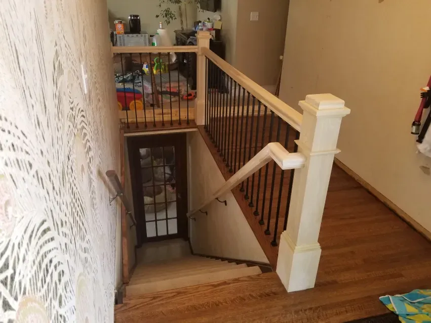 A staircase with a white railing and a wooden floor
