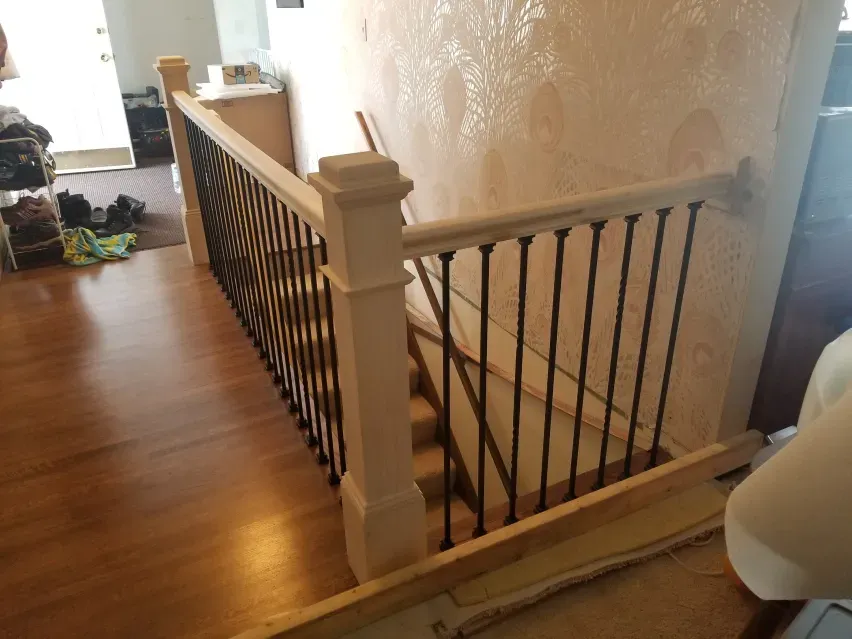 A wooden staircase with a metal railing in a house.