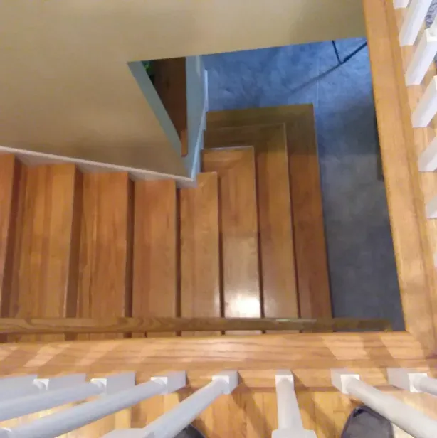 A person is standing on a set of wooden stairs.