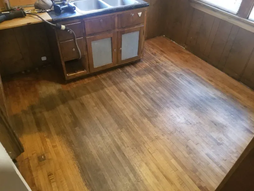 A kitchen with a wooden floor and a sink.