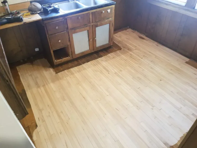 A kitchen with a wooden floor and a sink.