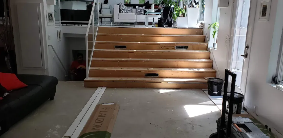 A living room with stairs going up to the second floor