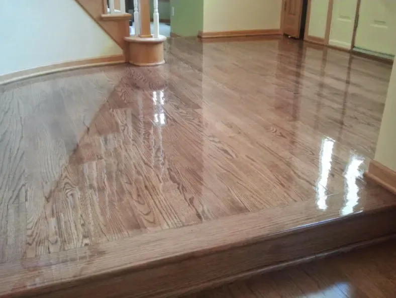 A wooden floor with a staircase in the background.