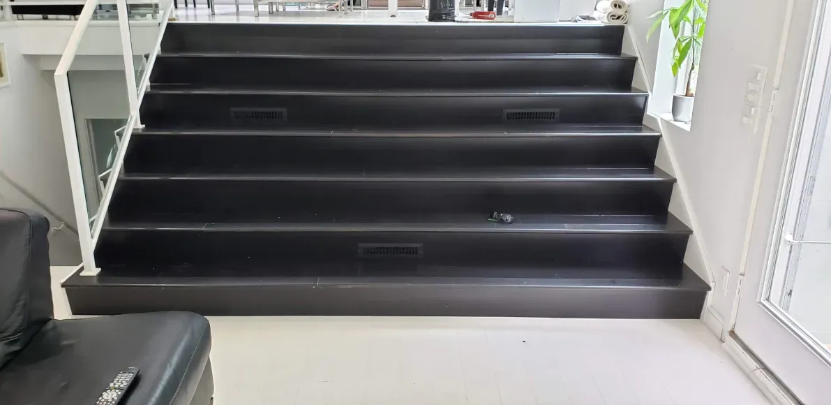 A set of black stairs leading up to the second floor of a building.