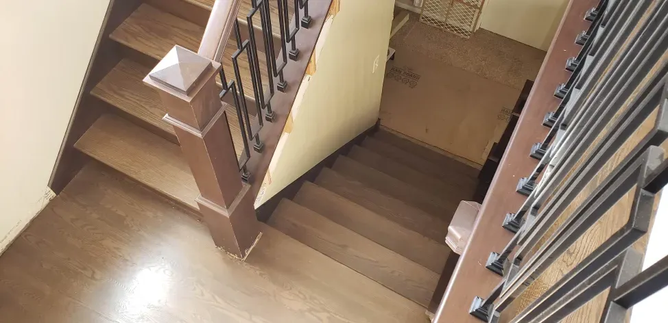 A wooden staircase with a metal railing in a house.